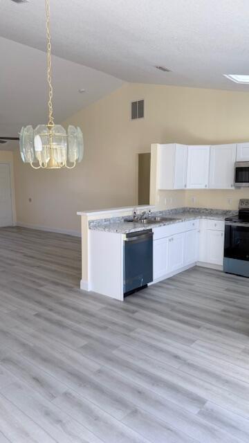 4262 Southwest Jared Street Port St. Lucie, FL 34953 - Photo 3 of 29 a large kitchen with cabinets wooden floor and stainless steel appliances