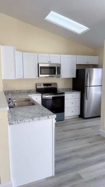 4262 Southwest Jared Street Port St. Lucie, FL 34953 - Photo 9 of 29 a kitchen with a sink a stove top oven and refrigerator