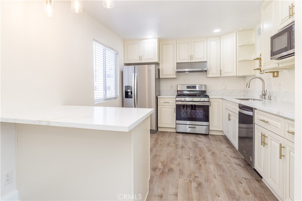 7809 Vía Udine Burbank, CA 91504 - Photo 2 of 34 a kitchen with stainless steel appliances granite countertop a stove top oven a sink and white cabinets
