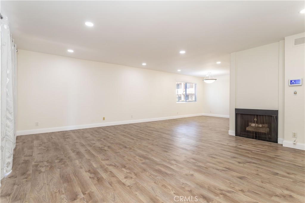 7809 Vía Udine Burbank, CA 91504 - Photo 3 of 34 an empty room with wooden floor and fireplace
