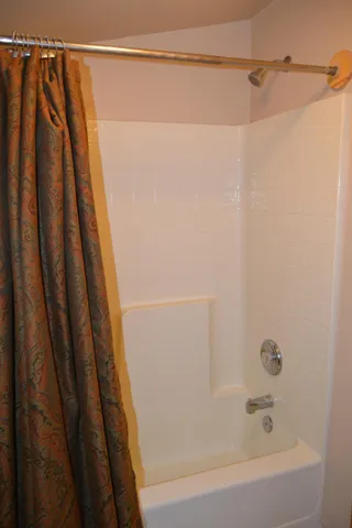 a bathroom with a shower and a bath tub