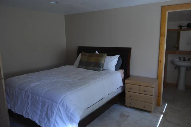 a bedroom with a bed and a night stand