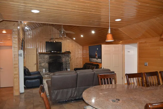 a living room with couches and kitchen view with wooden floor