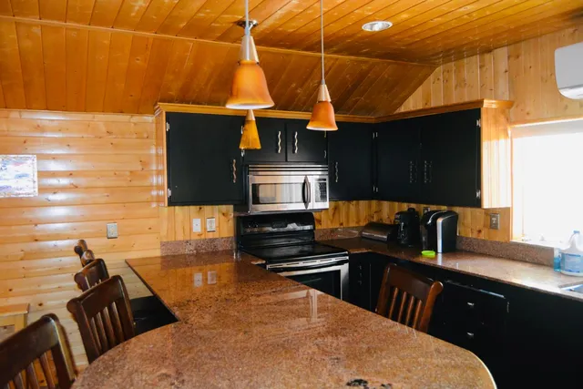 a kitchen with stainless steel appliances a stove a sink a microwave and refrigerator