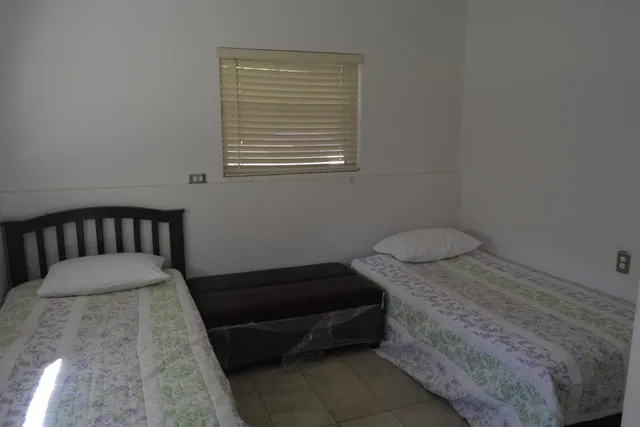 a bed sitting in a bedroom next to a window