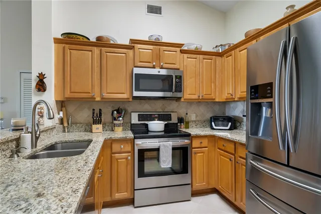 a kitchen with stainless steel appliances granite countertop a refrigerator stove and sink