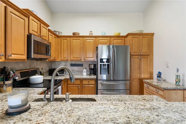 a kitchen with a refrigerator sink and cabinets
