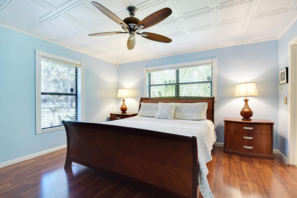 15429 Jupiter Farms Road Jupiter, FL 33478 - Photo 30 of 59 a bed room with a bed window and a ceiling fan