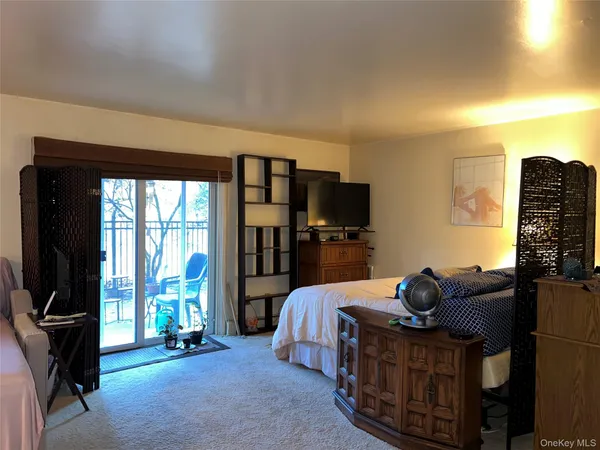 a living room with furniture a flat screen tv and a floor to ceiling window
