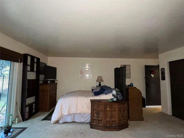 a living room with furniture flat screen tv and a refrigerator