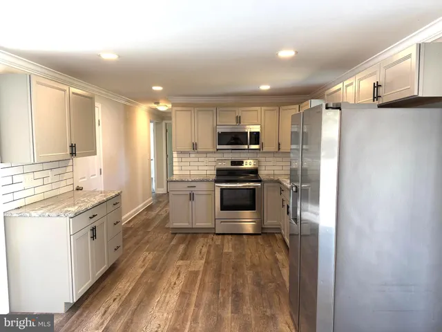 a kitchen with stainless steel appliances a refrigerator stove microwave and sink