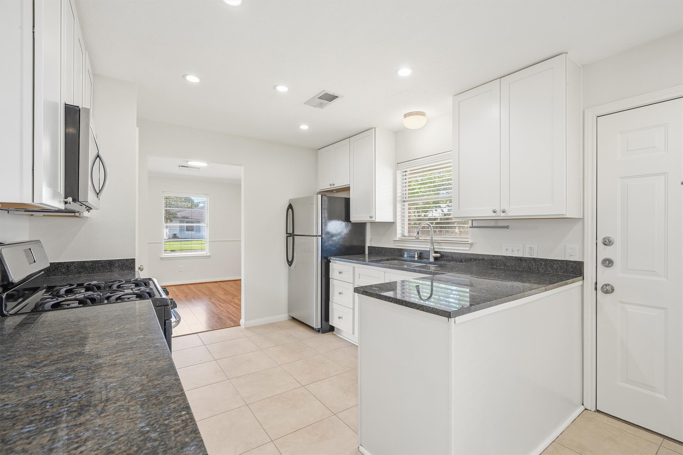 3331 Arbor Street Houston, TX 77004 - Photo 13 of 30 The space is well-lit with recessed lighting and has tile flooring. A window offers natural light, and there's a view into a room with hardwood flooring.