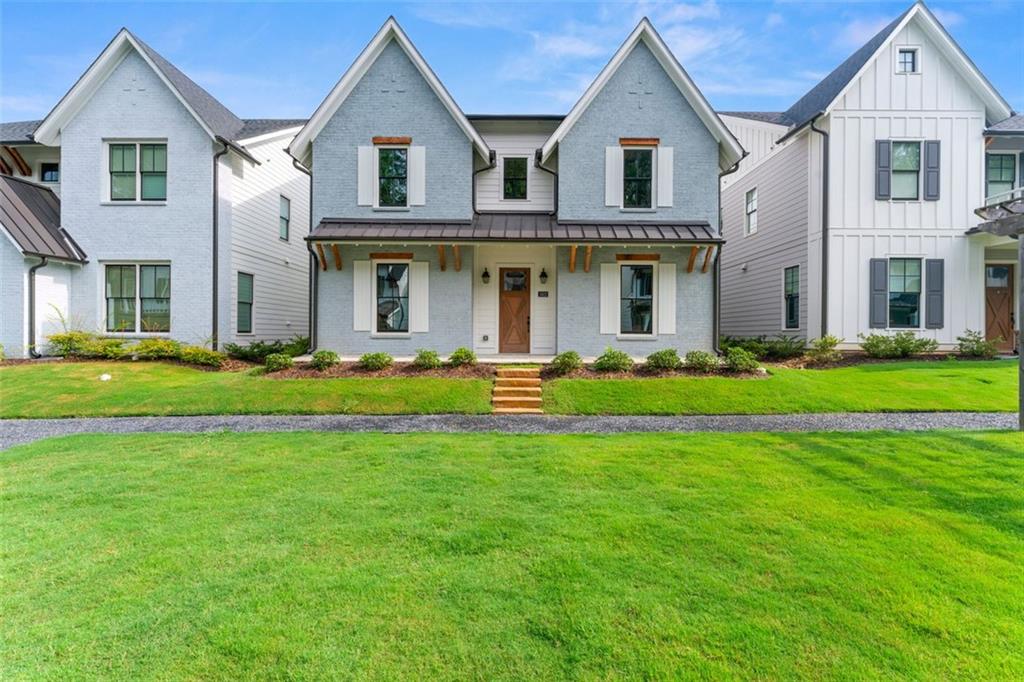 a front view of a house with a big yard and potted plants