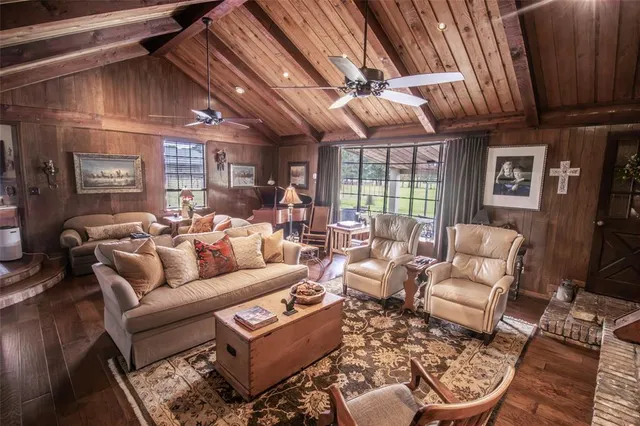 a living room with furniture a fireplace and a chandelier
