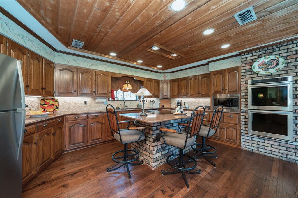 3843 Farm To Market 2199 Marshall, TX 75672 - Photo 7 of 40 a kitchen with stainless steel appliances kitchen island granite countertop a table chairs sink and cabinets
