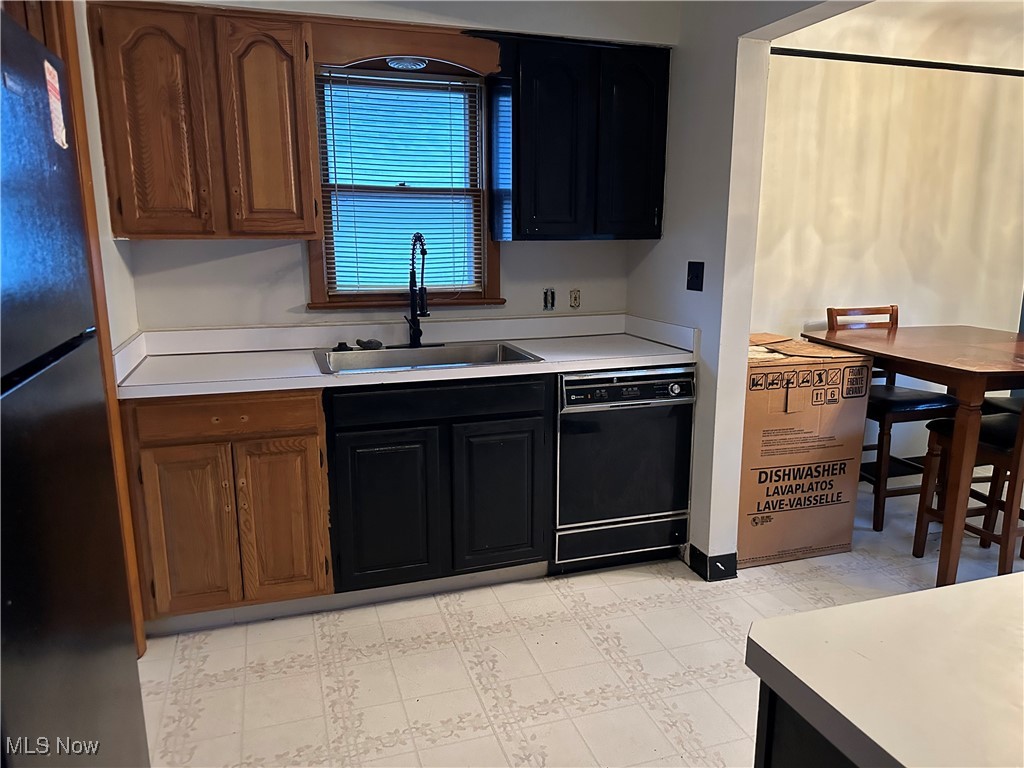 12303 Orme Road Garfield Heights, OH 44125 - Photo 8 of 22 Kitchen featuring black appliances, light countertops, and a sink