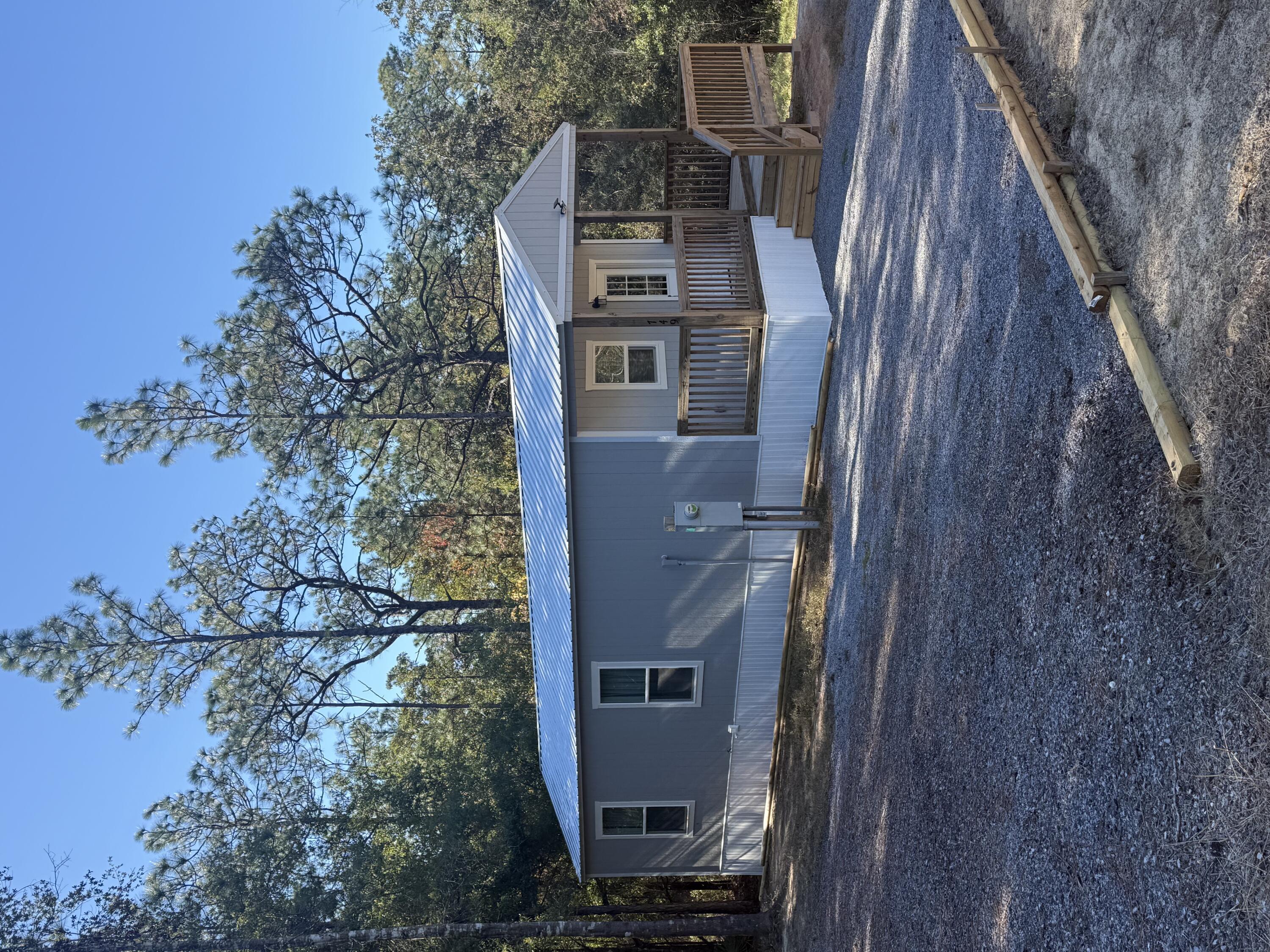 a front view of house with yard and trees in the background