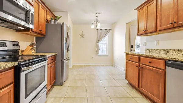 a kitchen with stainless steel appliances granite countertop a stove a sink and a refrigerator