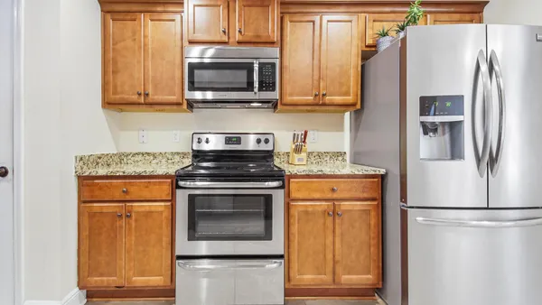 a kitchen with stainless steel appliances granite countertop a refrigerator stove and microwave