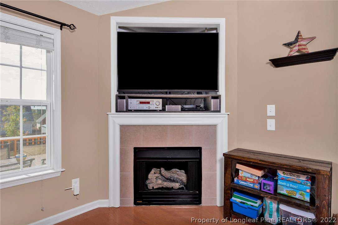 5407 Spreading Branch Road Hope Mills, NC 28348 - Photo 8 of 22 a living room with a fireplace and a flat screen tv