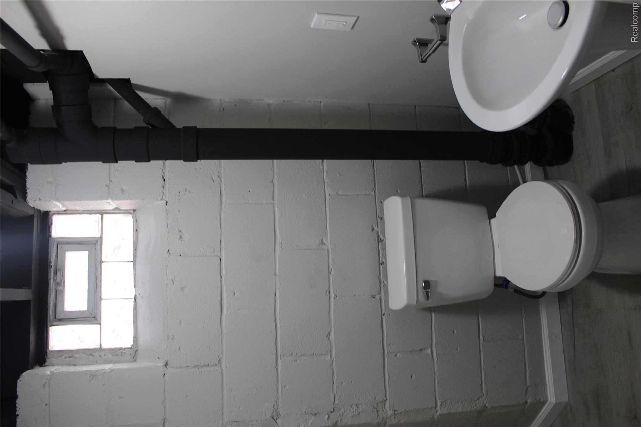 5543 Balfour Road Detroit, MI 48224 - Photo 32 of 54 Bathroom featuring a white toilet, pedestal sink, and light gray wood-finish flooring