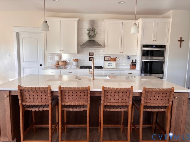 11537 Mt Hope Church Road Doswell, VA 23047 - Photo 4 of 10 a kitchen with stainless steel appliances kitchen island granite countertop a table chairs and a refrigerator