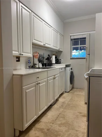 a kitchen with white cabinets and white appliances