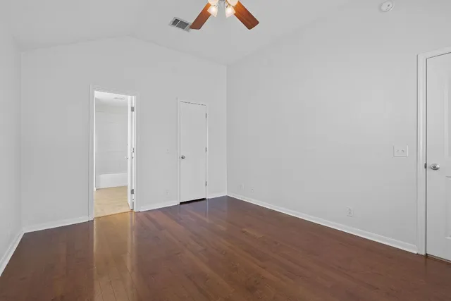 an empty room with ceiling fan and window