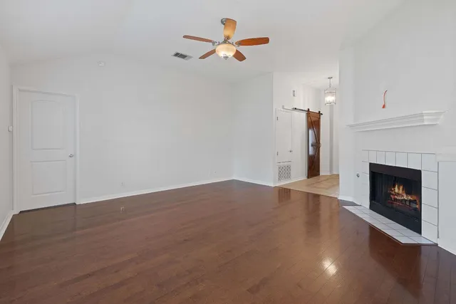 an empty room with fan and fireplace
