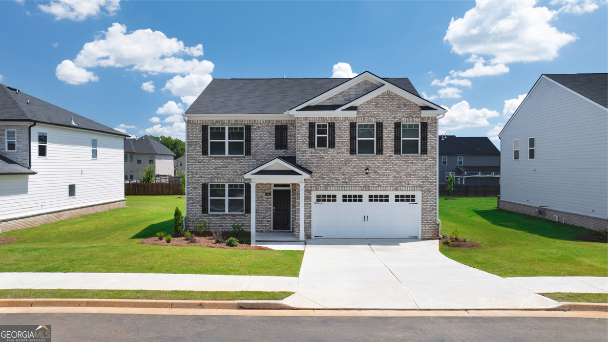 a front view of a house with a yard and garage