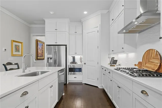 a kitchen with stainless steel appliances sink a stove and cabinets