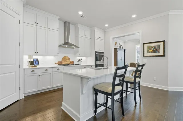 a kitchen with cabinets a sink and chairs in it