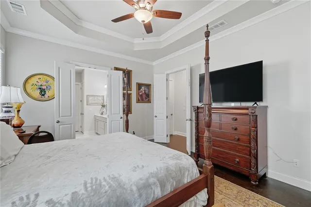 a bedroom with a bed and a flat tv screen on dresser