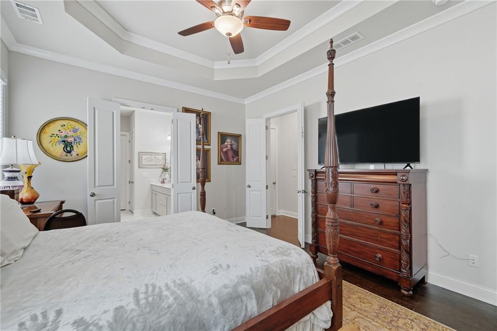 514 Homestead Park Place Canton, GA 30115 - Photo 21 of 38 a bedroom with a bed and a flat tv screen on dresser