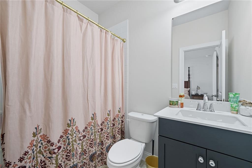 514 Homestead Park Place Canton, GA 30115 - Photo 31 of 38 a bathroom with a toilet a sink and a mirror