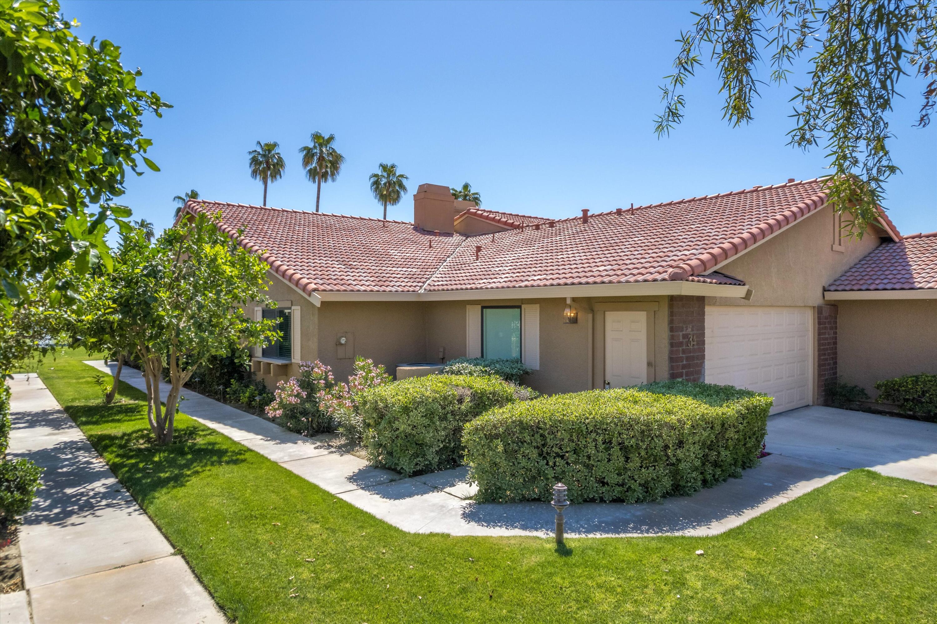 34 Maximo Way Palm Desert, CA 92260 - Photo 5 of 31 a front view of a house with a yard and outdoor seating