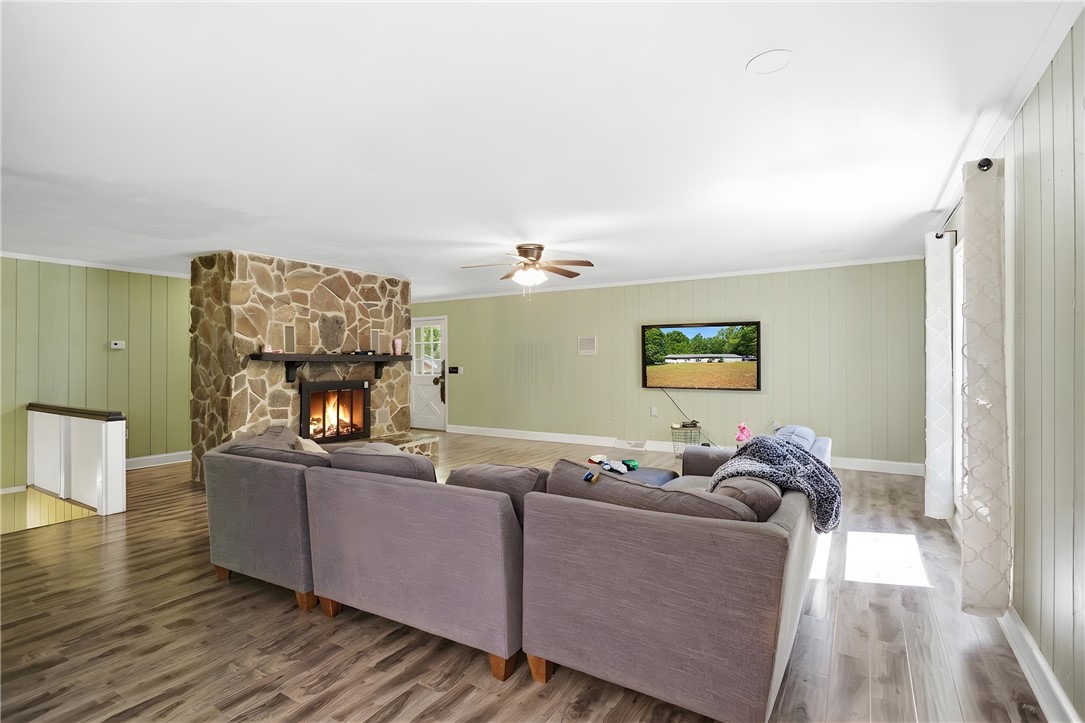 311 Cumberland Way Anderson, SC 29621 - Photo 4 of 44 A spacious living room features a striking stone fireplace and durable wood-look flooring.