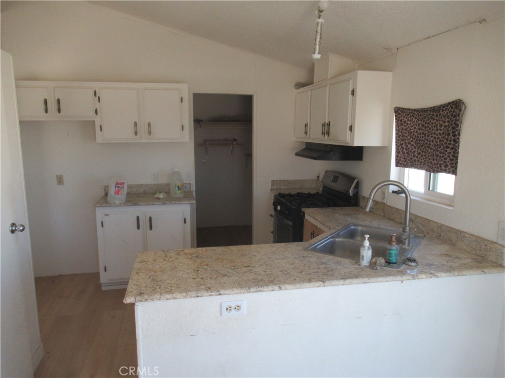14555 Artesia Trail Santa Margarita, CA 93453 - Photo 14 of 21 a kitchen with granite countertop a sink a stove and a refrigerator