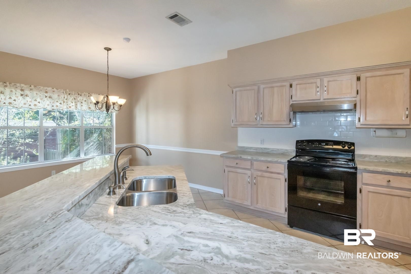 6117 Lennox Place Mobile, AL 36693 - Photo 13 of 39 Kitchen with visible vents, under cabinet range hood, a sink, light tile patterned floors, and black / electric stove