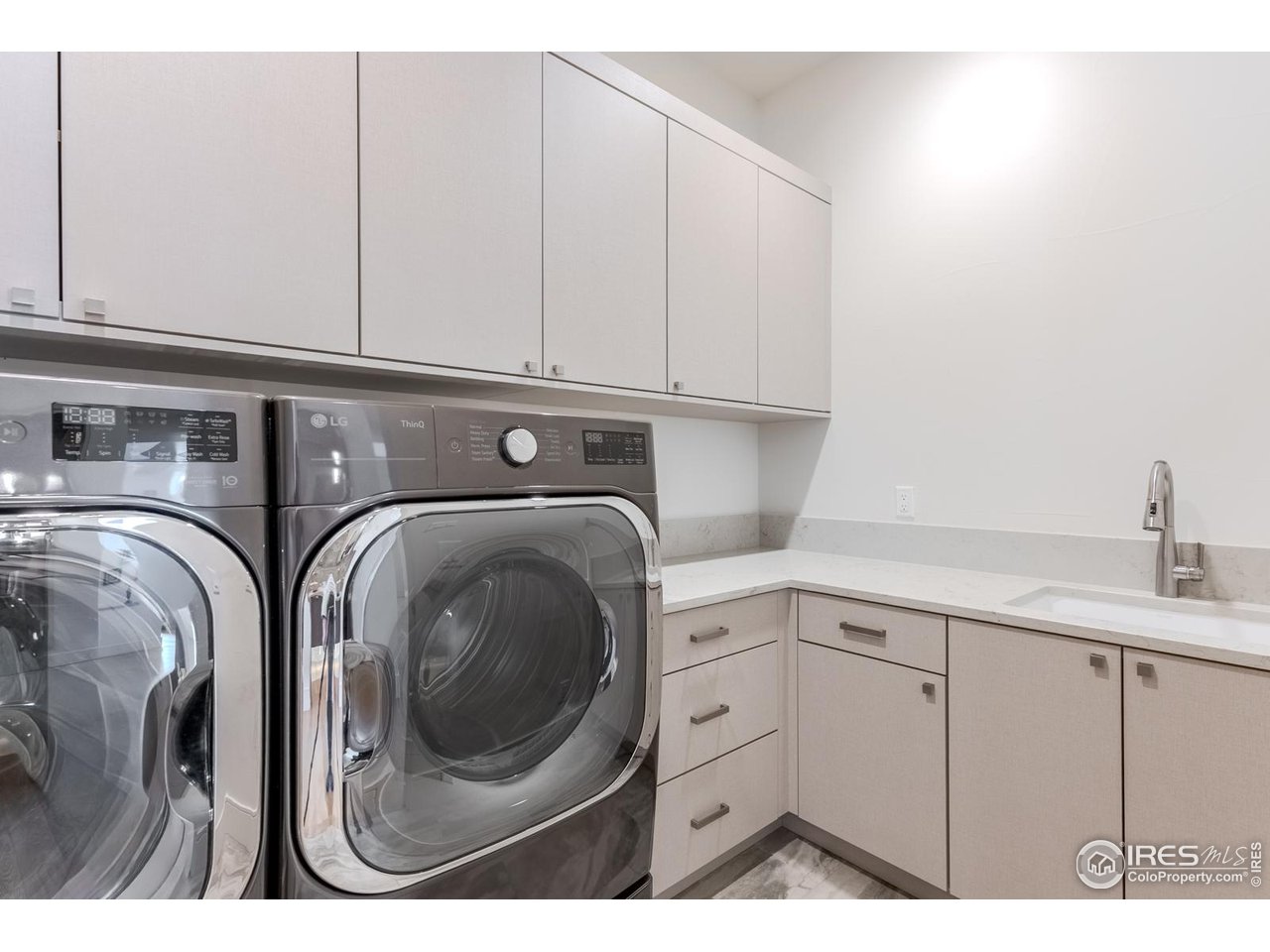 7572 Raphael Lane Littleton, CO 80125 - Photo 26 of 50 The upscale laundry room combines style and function with sleek cabinetry for organized storage, a convenient built-in sink, and a high-performance washer and dryer. Thoughtful design and premium finishes make everyday tasks feel effortless and refined.
