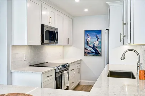 a kitchen with stainless steel appliances granite countertop a stove a sink and a microwave