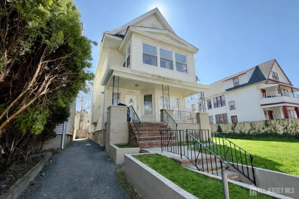 a view of a house with wooden fence and a yard