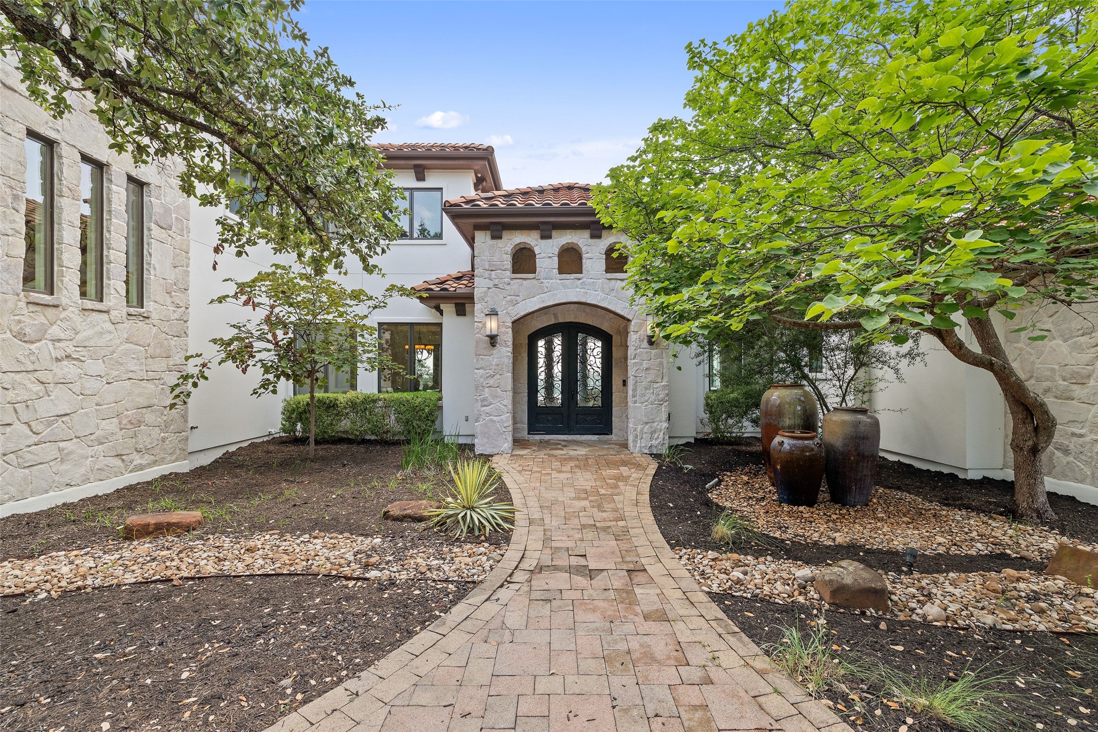 1414 The High Road Austin, TX 78746 - Photo 4 of 40 A graceful brick pathway leads to an inviting arched entryway of this distinctive residence.