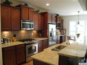 226 State Rd S-29-804 Fort Mill, SC 29707 - Photo 2 of 16 a kitchen with kitchen island granite countertop wooden cabinets a stove top oven a sink and dishwasher