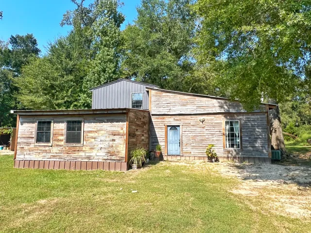 a view of a house with a backyard and a tree
