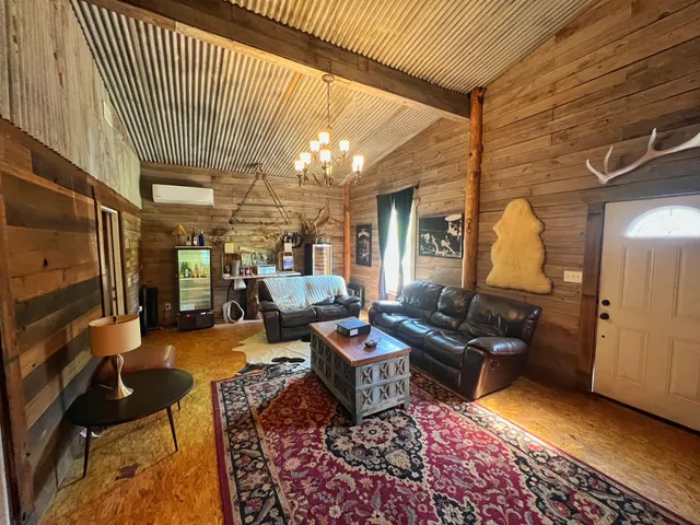 a living room with furniture a rug and white walls