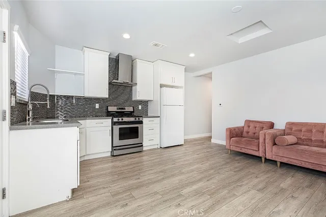 a kitchen with granite countertop white cabinets and stainless steel appliances
