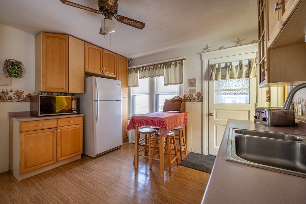 61 Bridge Road Northampton, MA 01062 - Photo 7 of 34 a kitchen with stainless steel appliances a refrigerator a stove a sink dishwasher a dining table and chairs with wooden floor