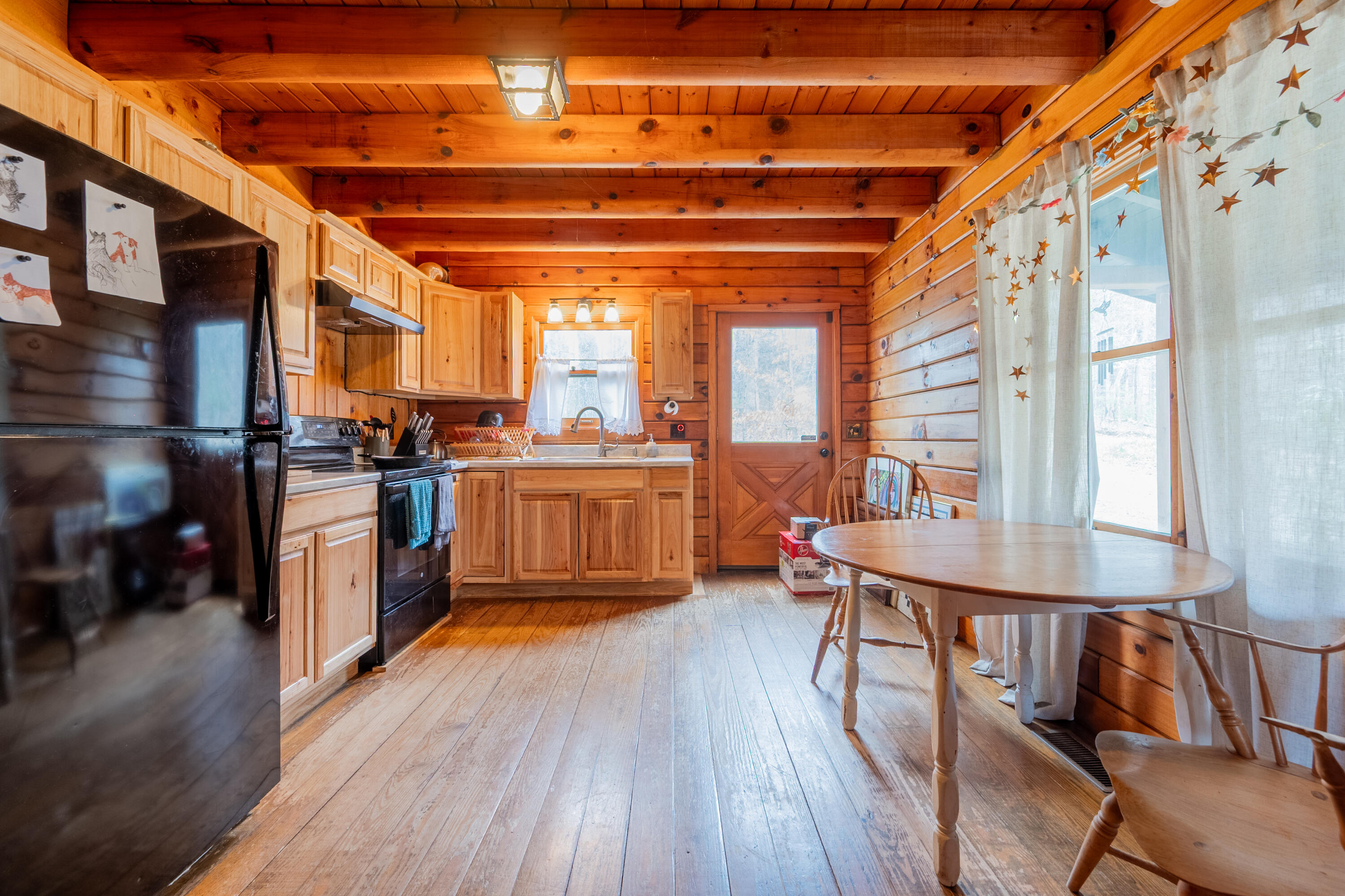 183 Pine Mountain Road Northeast Floyd, VA 24091 - Photo 15 of 54 a open kitchen with stainless steel appliances granite countertop a stove a refrigerator a dining table and chairs with wooden floor