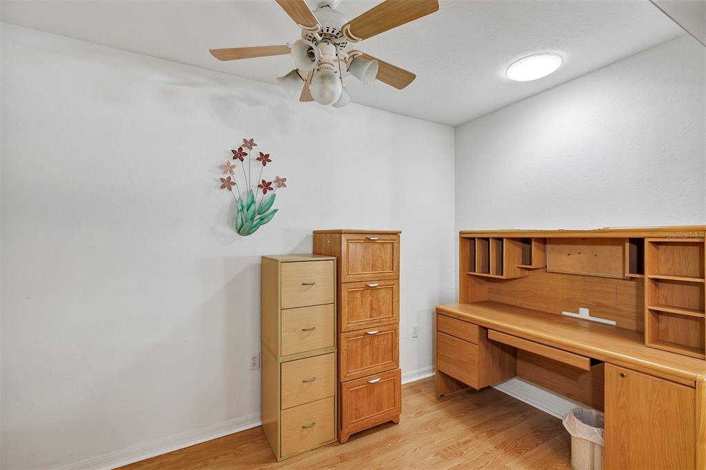 11447 Southwest 69th Circle Ocala, FL 34476 - Photo 12 of 32 a bedroom with a dresser and a chandelier